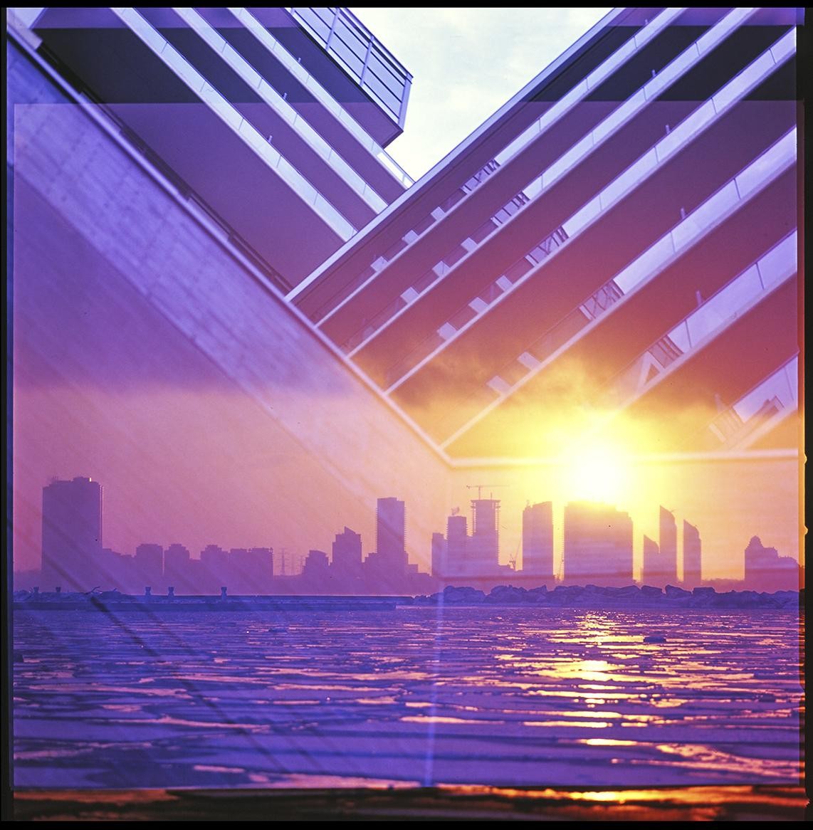 A double exposure shows a cityscape at sunset over a frozen lake, overlaid with a modern building facade.