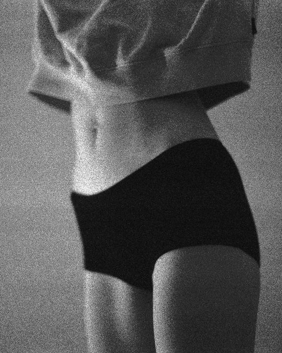A woman's torso is visible, wearing a cropped top and underwear.