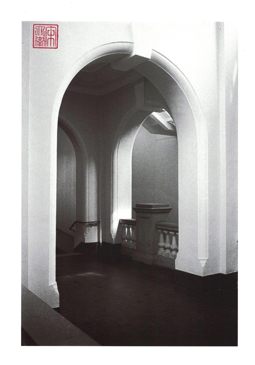 A series of neoclassical arches and a balustrade lead to a staircase.