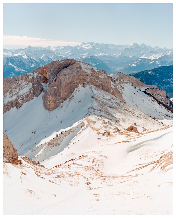 A snow-covered mountain range with a clear sky is visible in the distance.