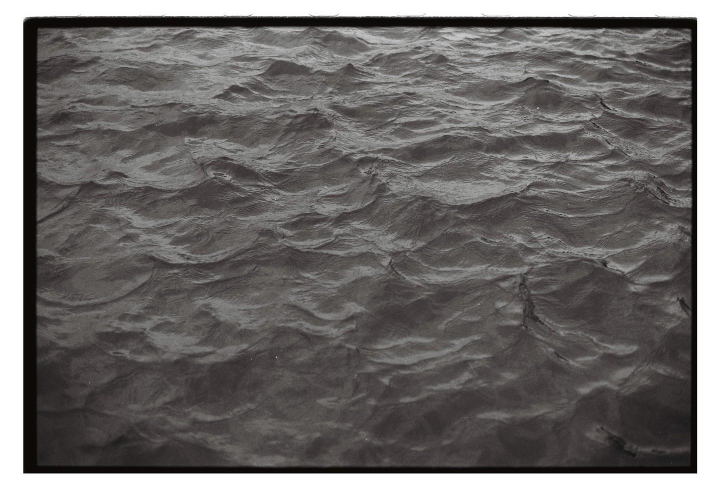 A close-up, high-angle view shows the surface of water with small waves.