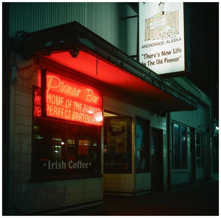 A red neon sign for the Pioneer Bar is illuminated at night in Anchorage, Alaska.
