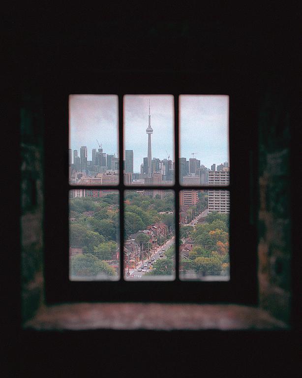 A view of downtown Toronto with the CN Tower is visible through a window.