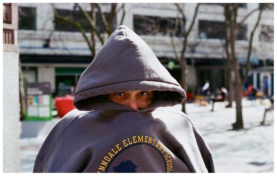 A person wearing a hooded sweatshirt with "Lynndale Elementary School" written on it looks directly at the viewer.