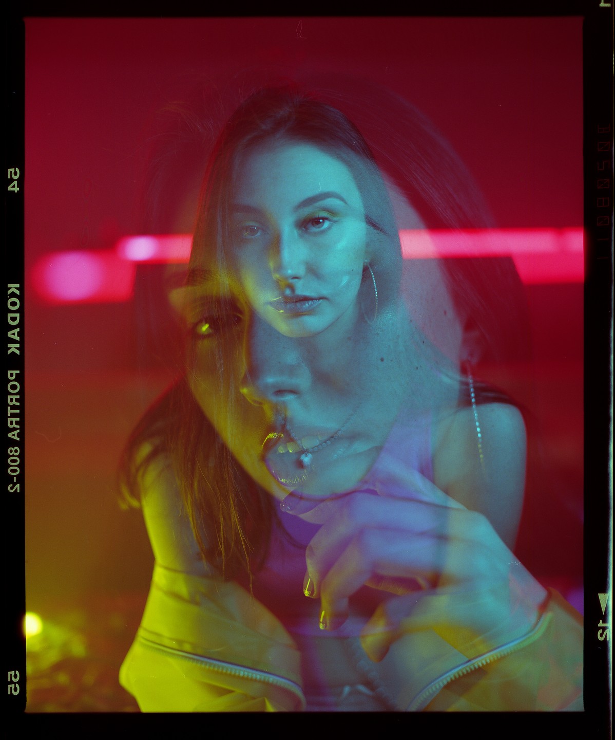 A woman's face is shown in a double exposure with red and yellow light.