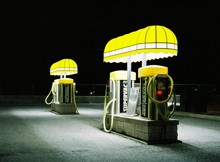 Two yellow Supervac vacuum cleaners with awnings are illuminated at night.