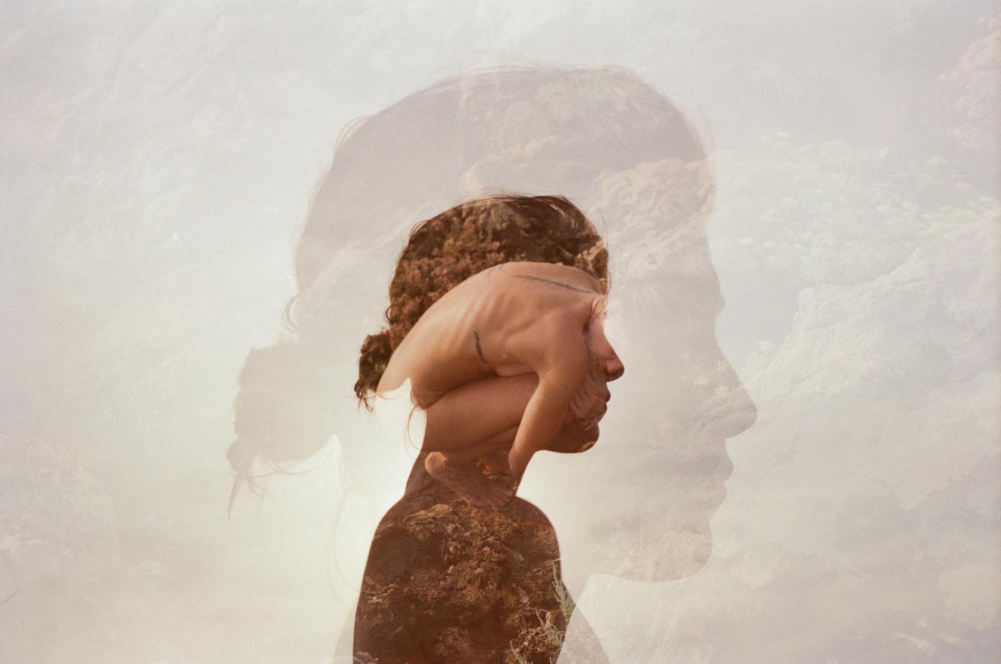 A triple exposure shows a woman's profile with a hand covering her face and a landscape superimposed over her body.