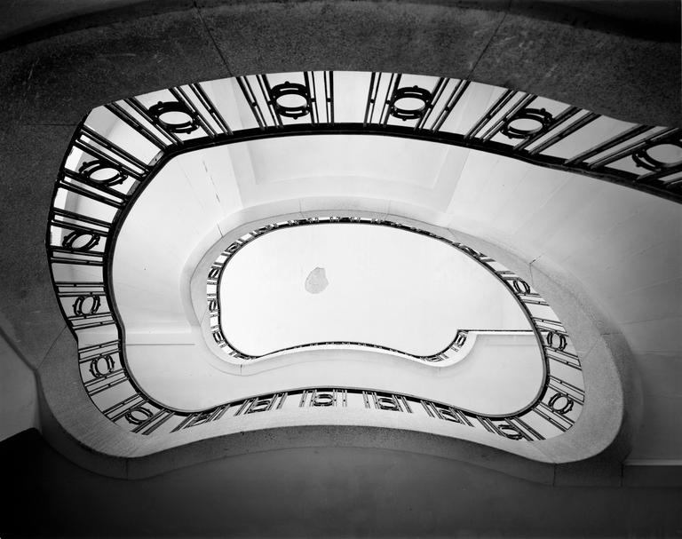 A low-angle view shows a spiral staircase with a decorative railing.