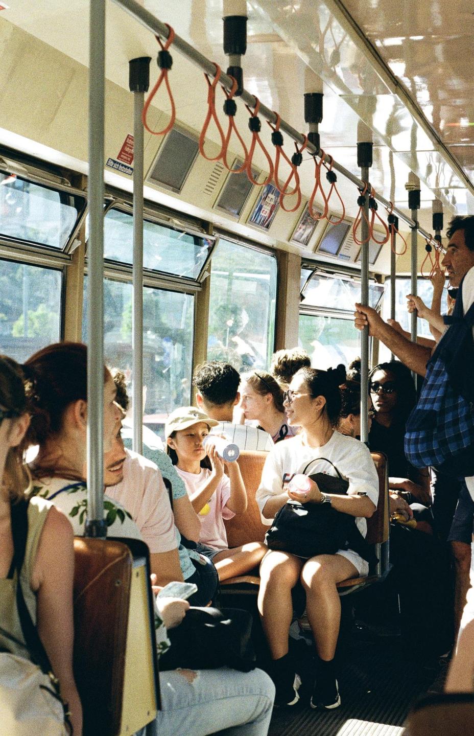 People are riding a tram on a sunny day.