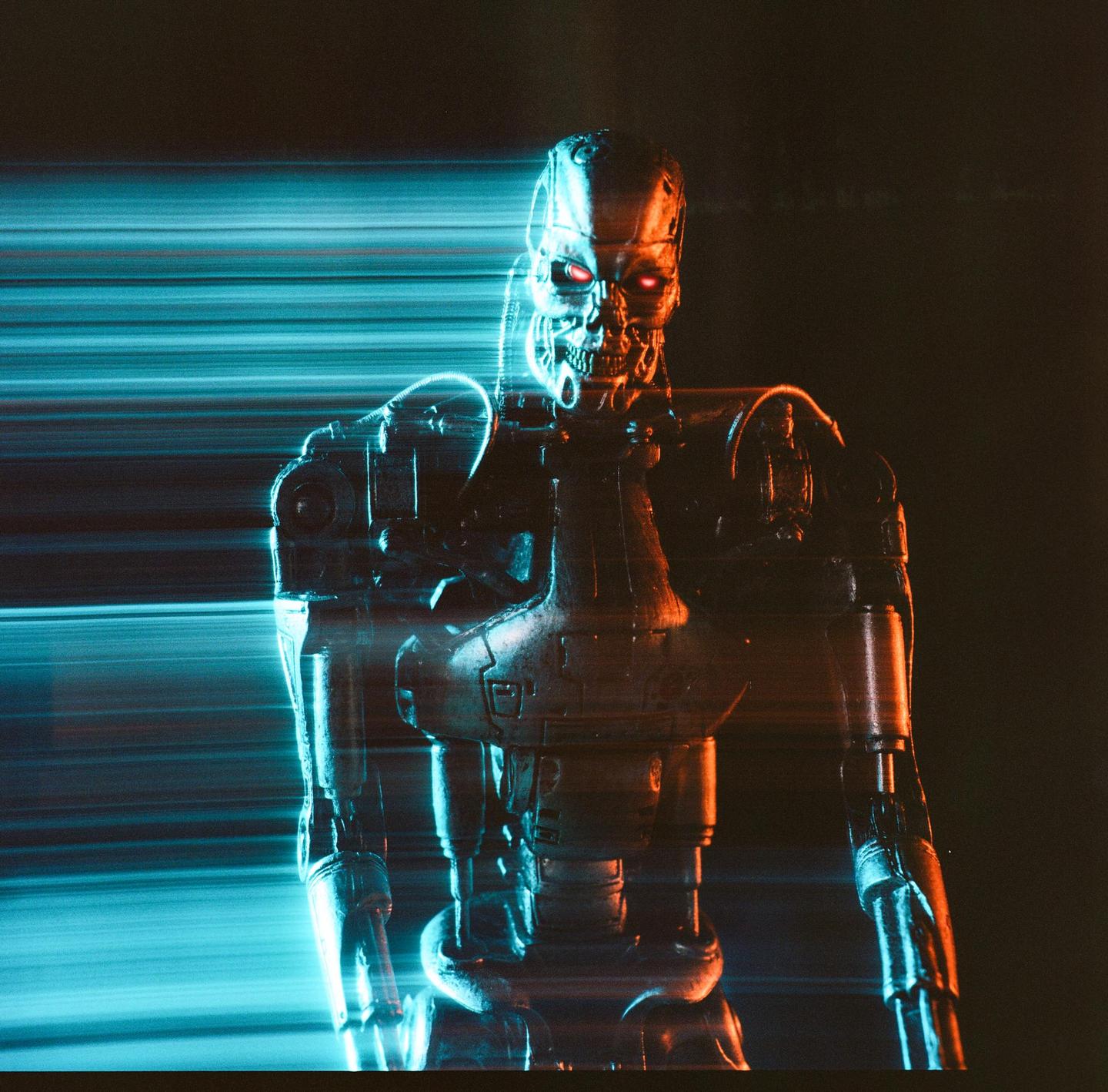 A metallic robot with glowing red eyes is captured with light streaks from a long exposure.