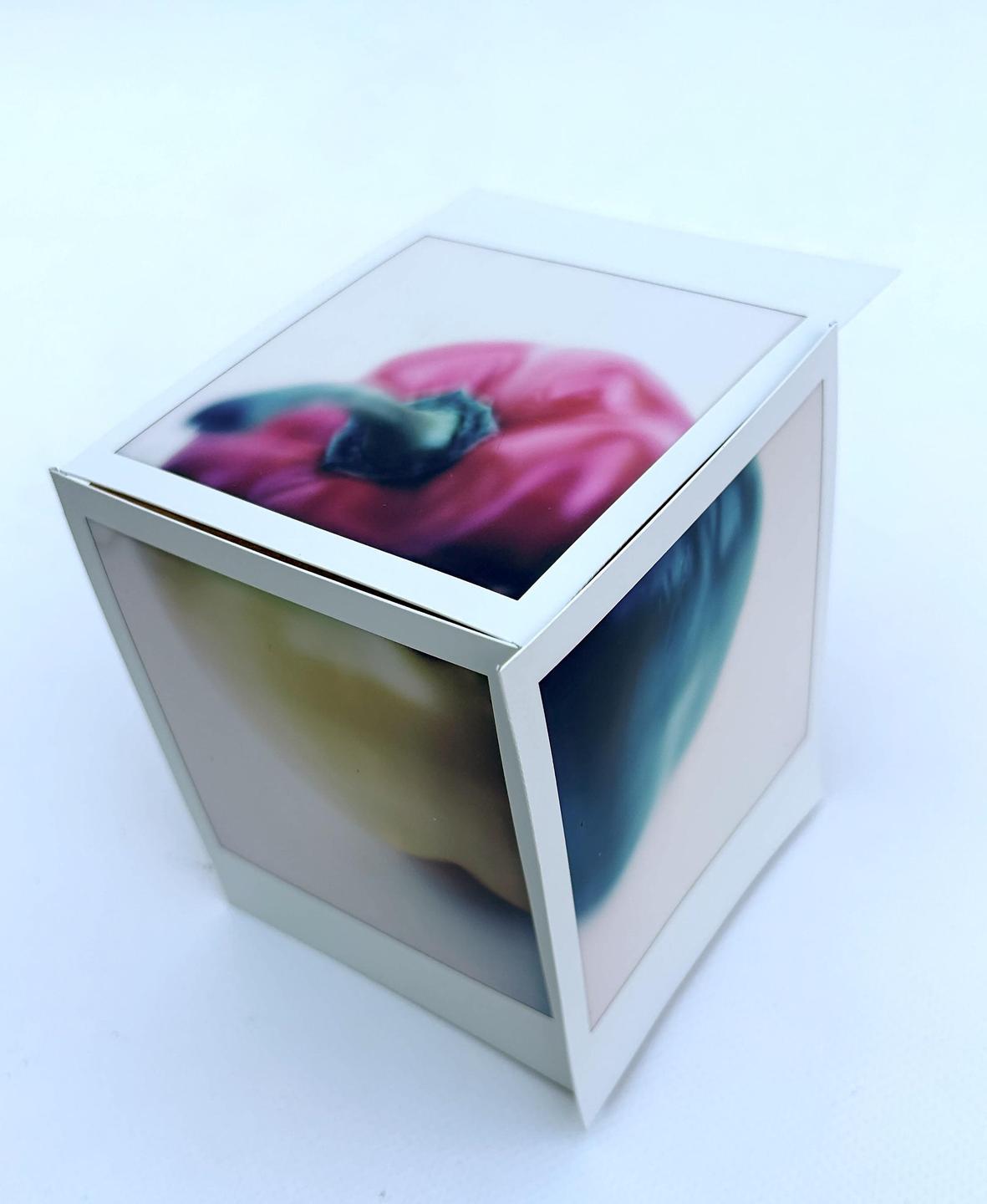 A white box with images of bell peppers on its sides is displayed against a white background.
