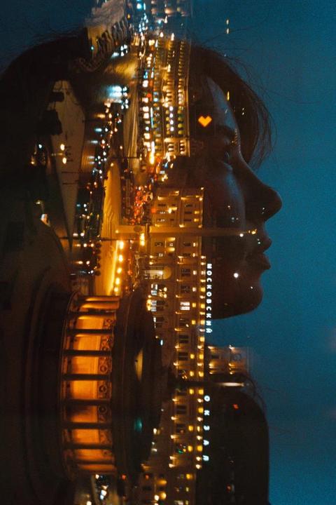 A double exposure shows a woman's profile overlaid with a city street at night, featuring a heart-shaped light.
