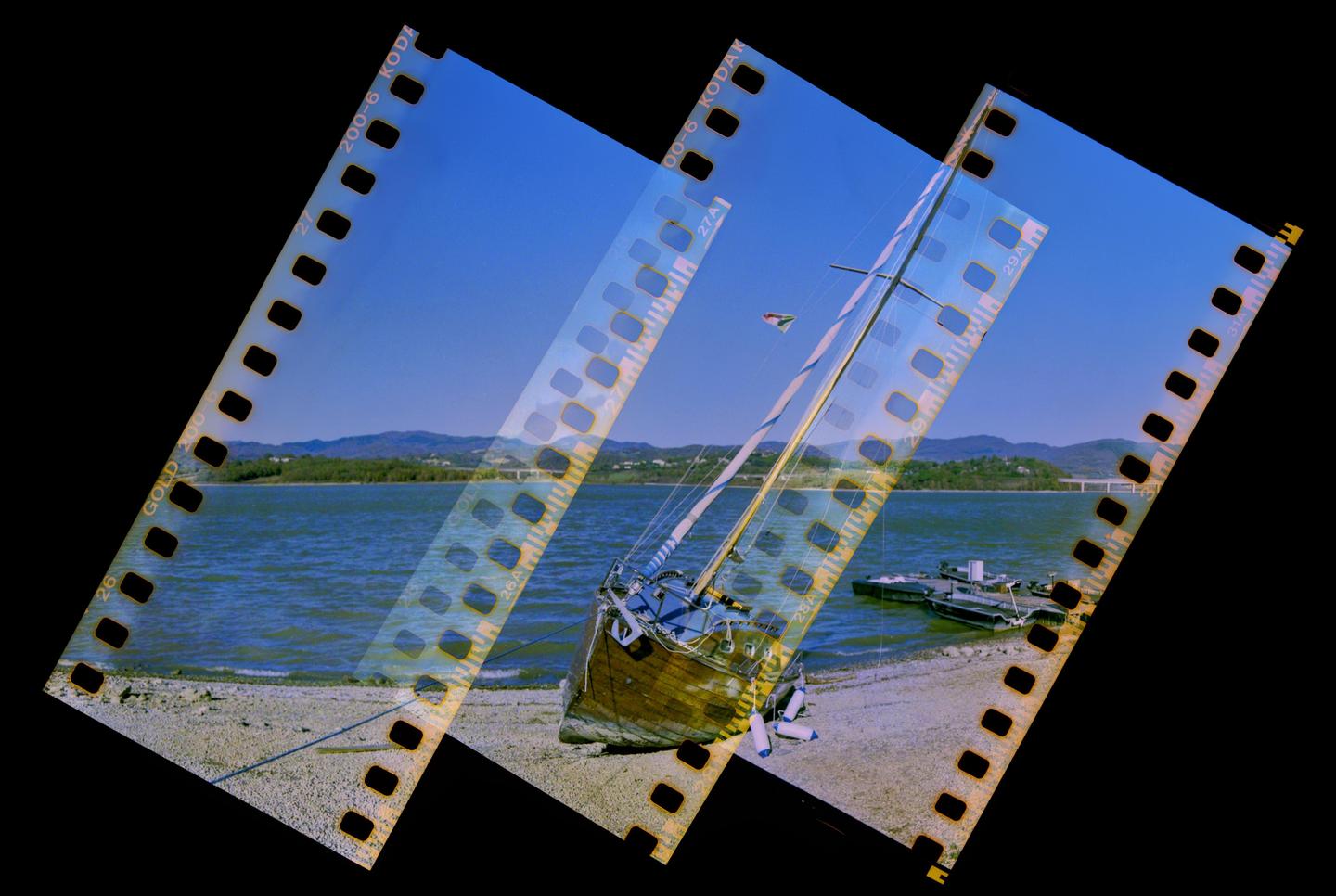 A boat is beached on a shore next to a body of water with hills in the background, overlaid with film strips.