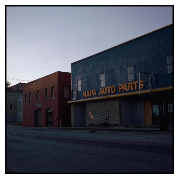 Two auto repair shops stand side by side on a street.