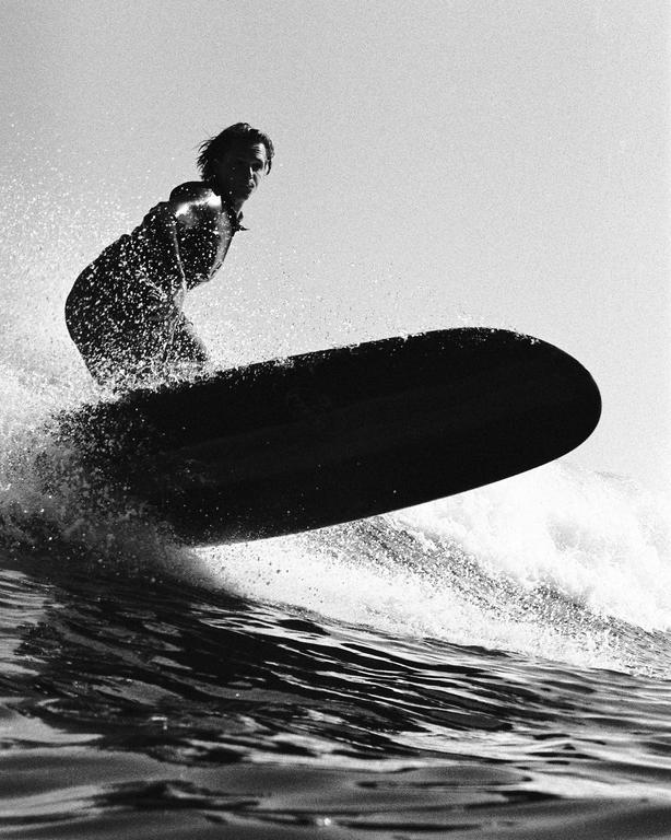 A surfer rides a wave on a surfboard.