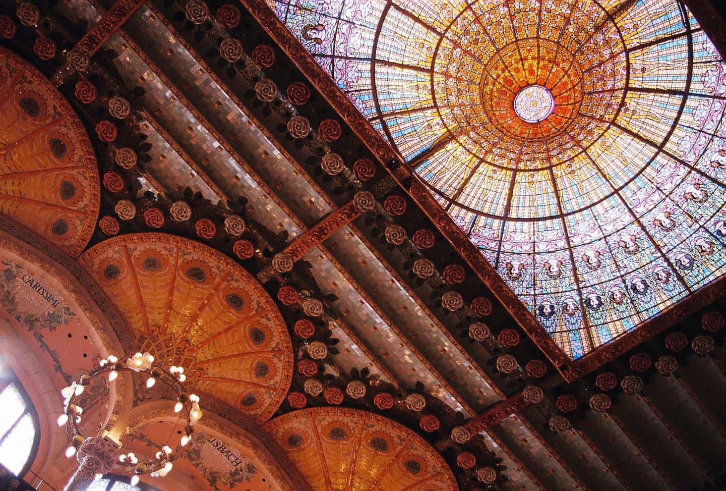 A stained glass dome and ornate ceiling with rose details are visible from below.
