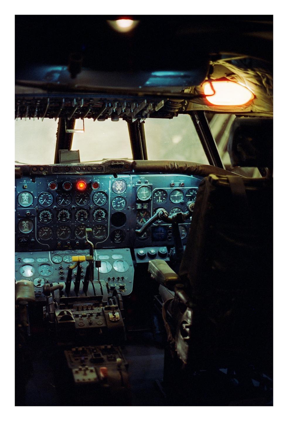 The cockpit of an airplane is visible with many gauges and controls.