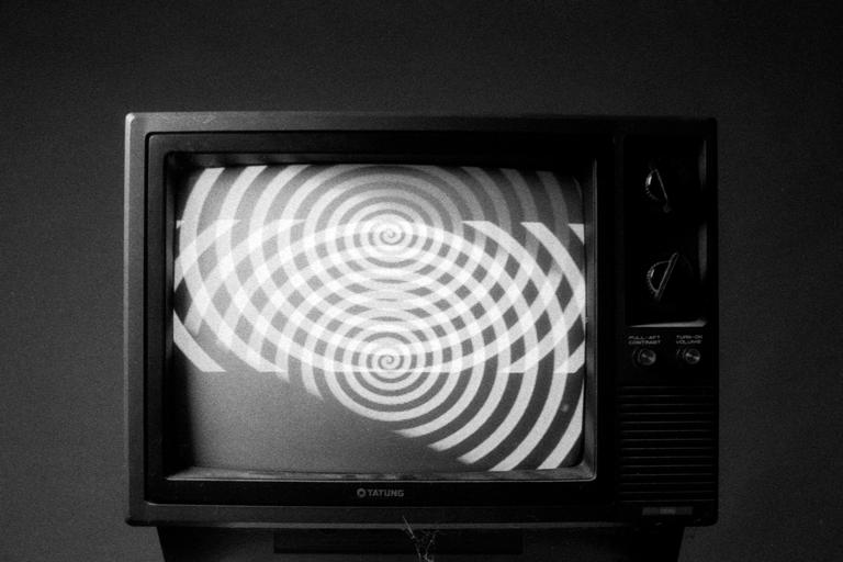A television displays a hypnotic spiral pattern on its screen.