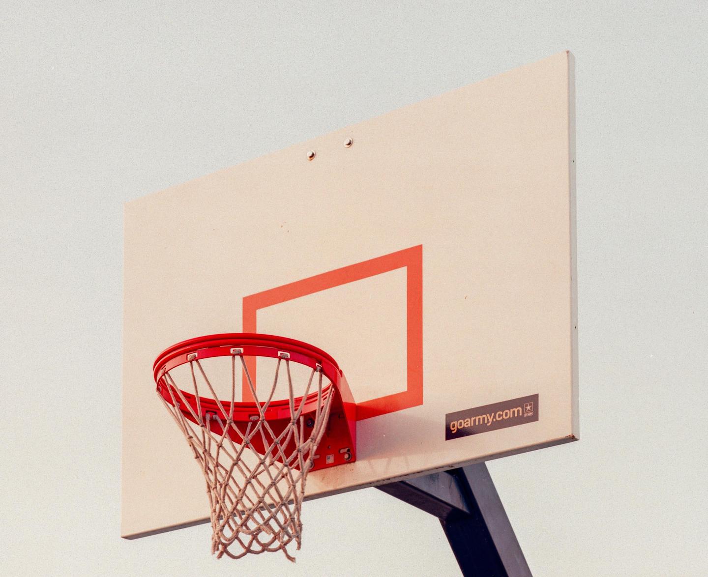 A red basketball hoop and net are attached to a white backboard with a red square.