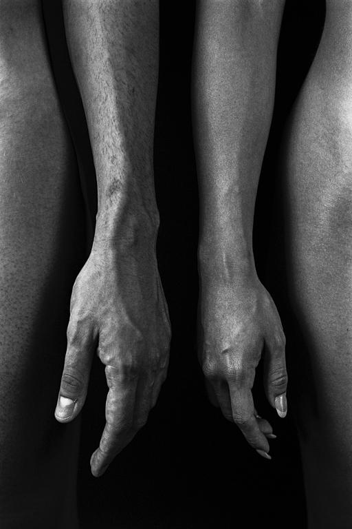 Two arms with hands hanging down are visible between two legs.