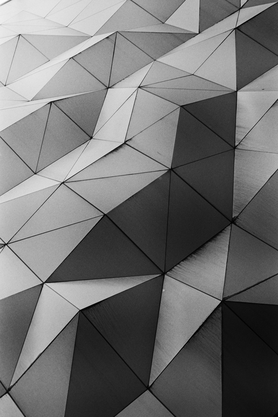 A close-up view shows a geometric pattern of triangles with varying shades.
