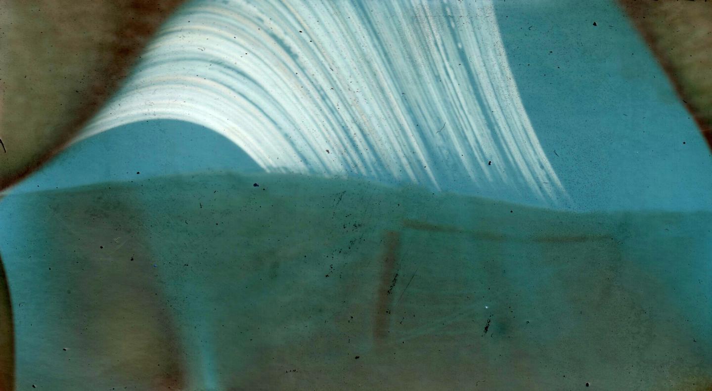 A light blue abstract shape with white streaks curves over a darker blue-green area.