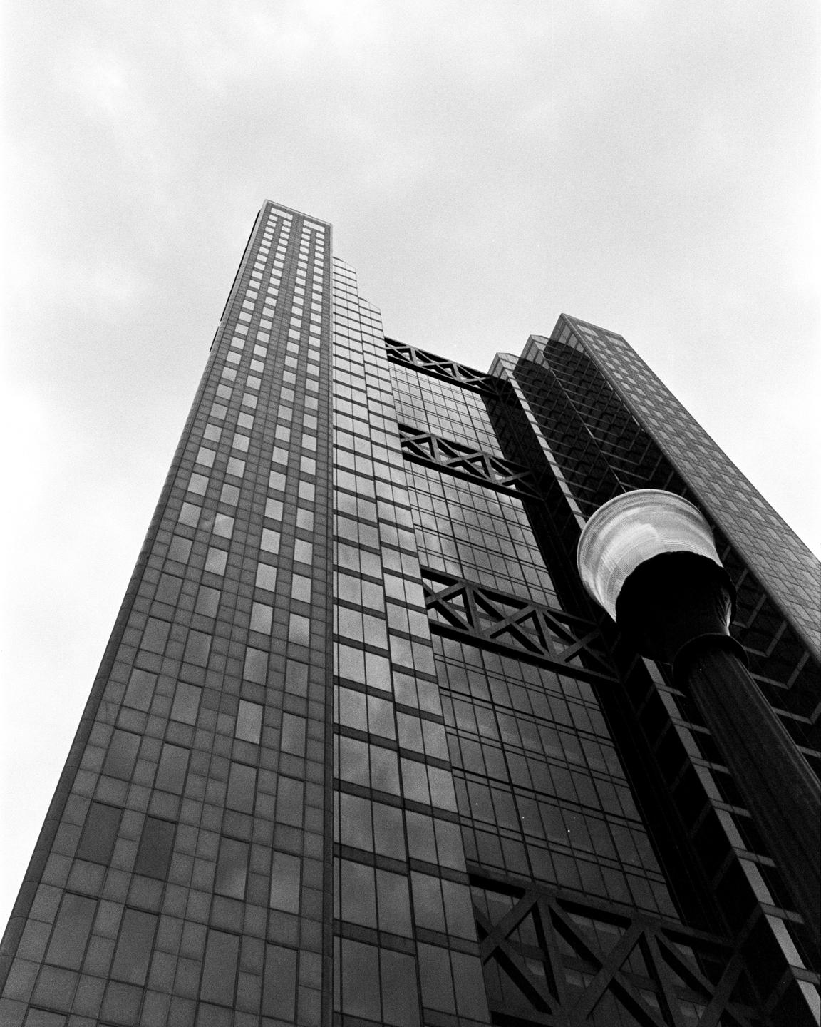 A low-angle view shows a tall building with many windows and a street light in the foreground.