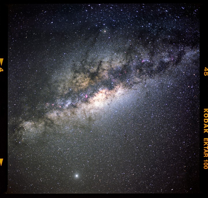 The Milky Way core is visible in the night sky with a bright planet below it.