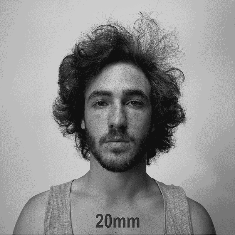 A man with curly hair and a beard looks directly at the viewer.