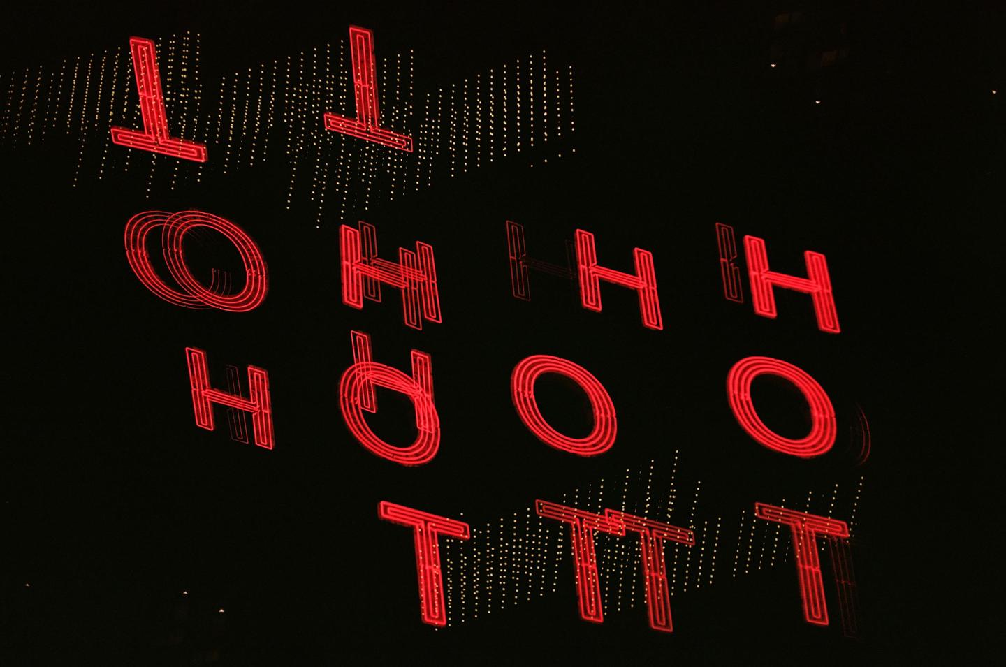 Red neon letters spelling "OHHH" and "ORH" are visible on a dark background.