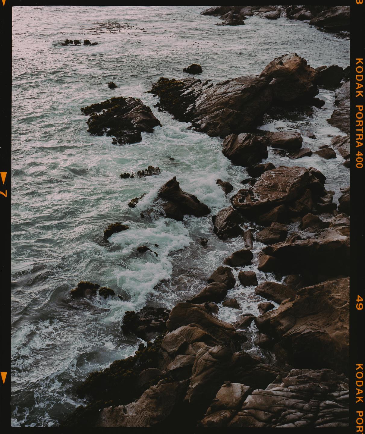 Waves crash against a rocky coastline.