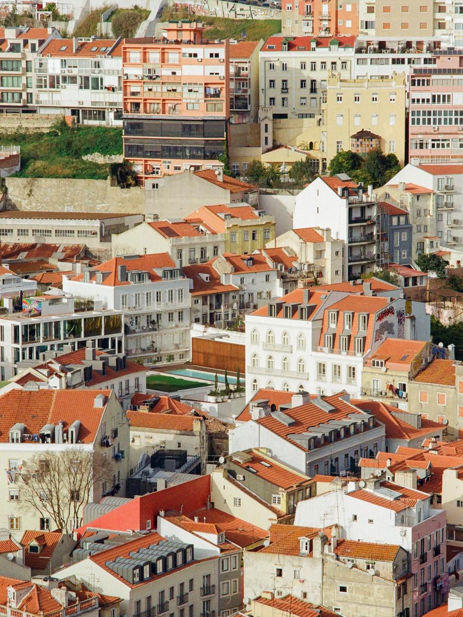 A dense hillside of buildings with red tile roofs is visible from above.