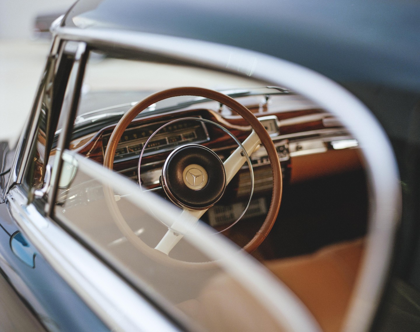 The interior of a vintage Mercedes-Benz car is visible through the open window.