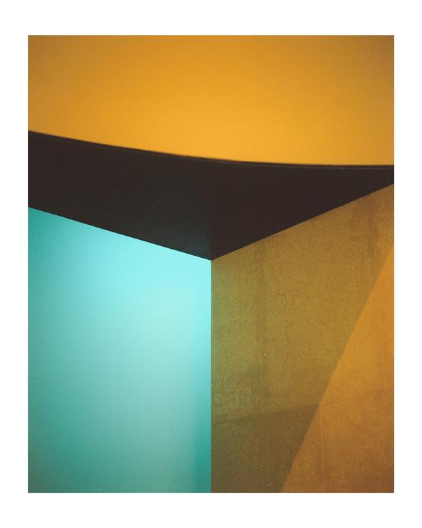 A wall is divided into sections of teal, dark brown, and gold.