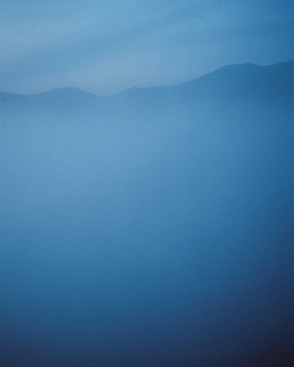 A hazy mountain range is visible through a blue fog.