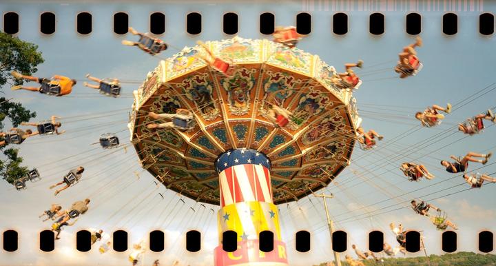 People are riding a swing ride at a summer fair.