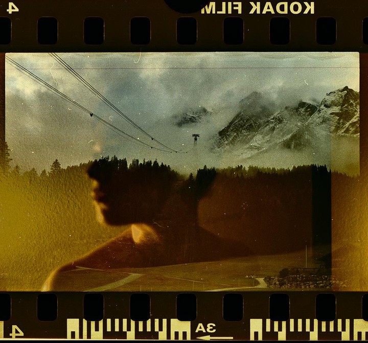 A double exposure shows a man's silhouette over a mountain landscape with a ski lift.
