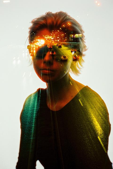 A double exposure shows a woman overlaid with a night street scene with cars and city lights.