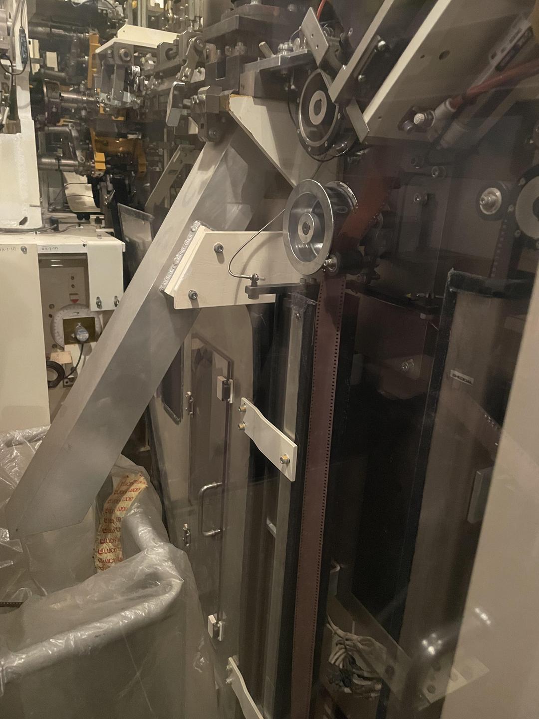 A strip of film is visible inside a machine with various gears and metal components.