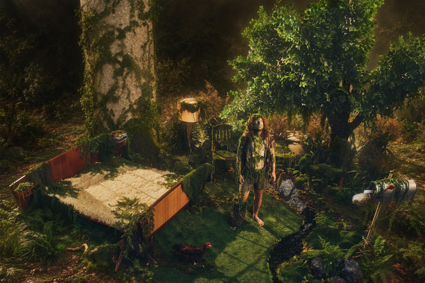 A man covered in moss stands barefoot in a lush, overgrown forest with a bed, chair, and lamp also covered in moss.