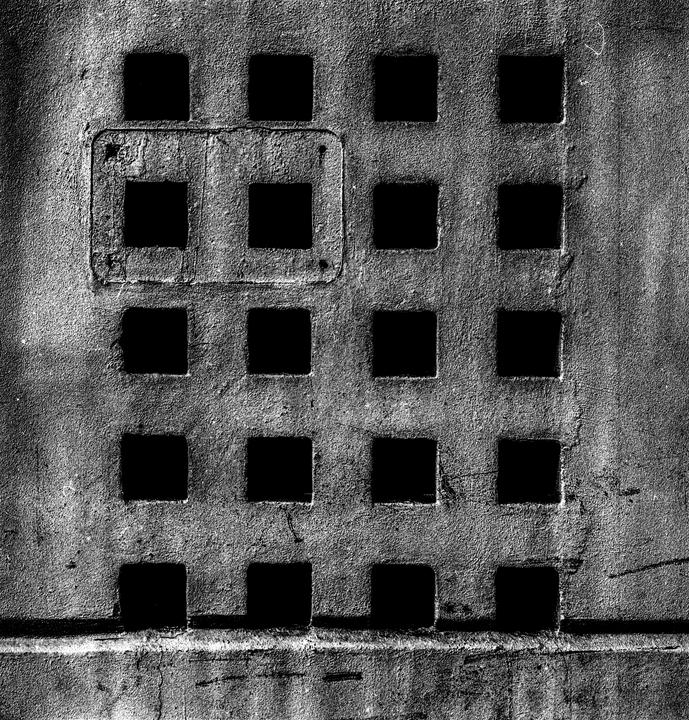 A grid of square holes is visible on a textured surface.