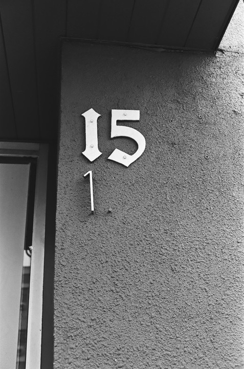 The number 15 is displayed on a textured wall next to a door frame.