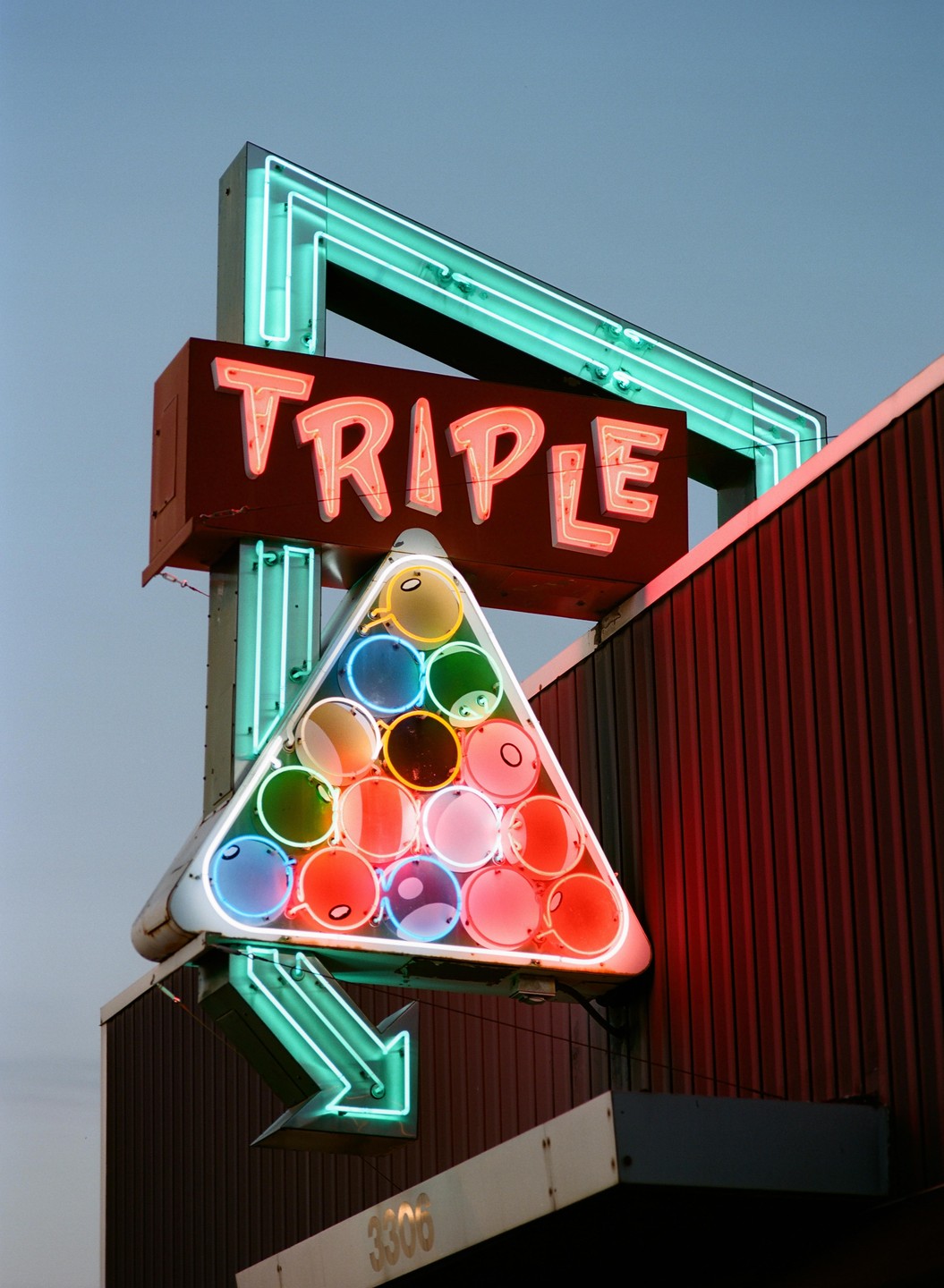 A neon sign for "Triple" features a triangular rack of billiard balls and a downward-pointing arrow.