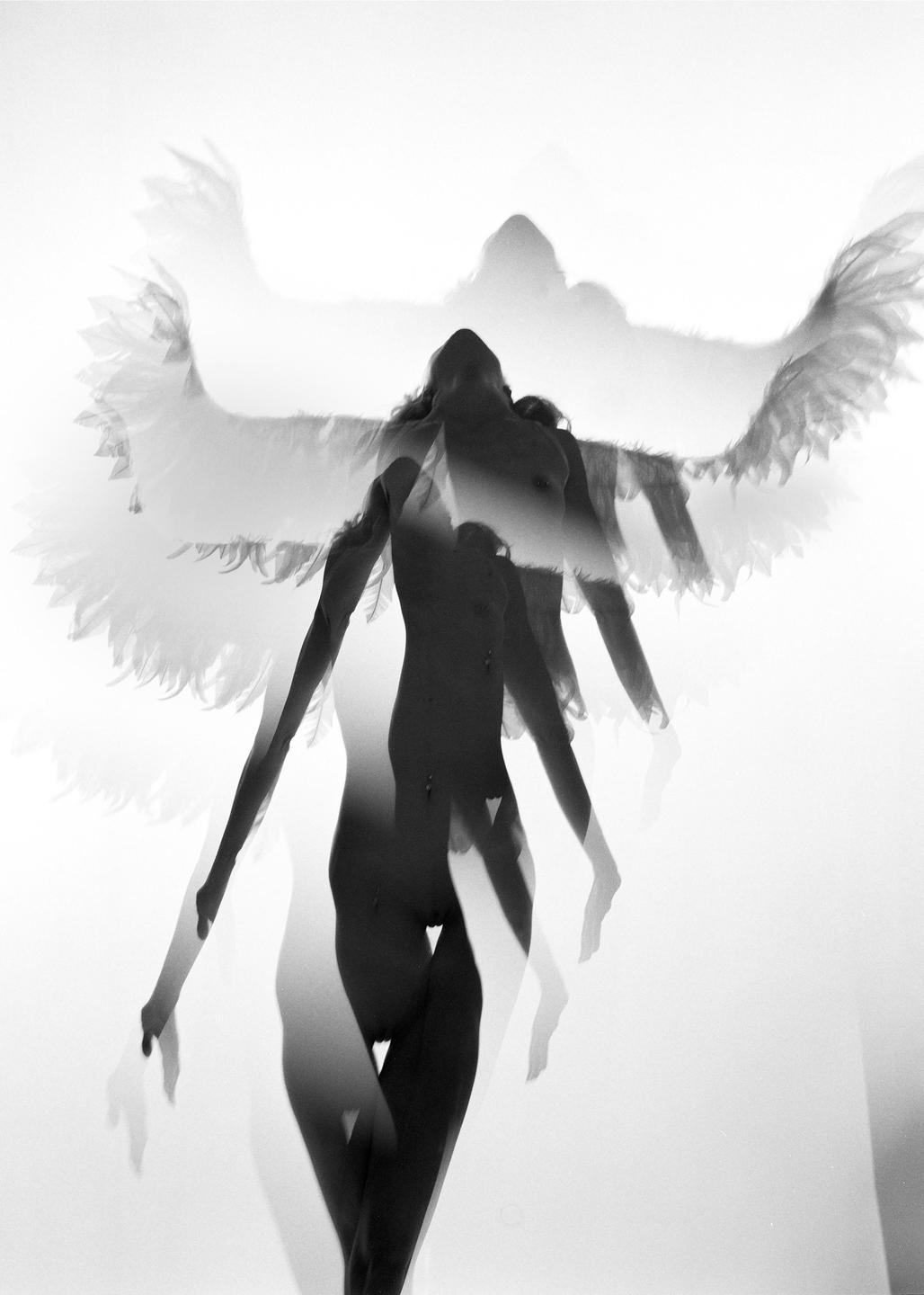 A nude woman with wings is captured in a multiple exposure against a bright background.