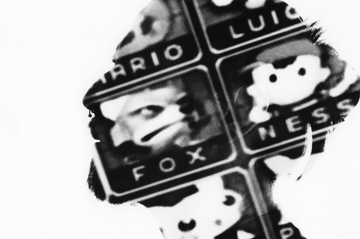 A man's profile is visible in a double exposure with a grid of video game characters.