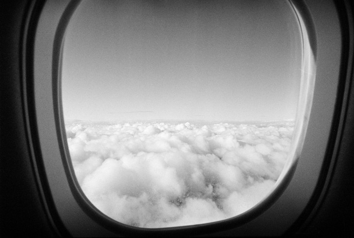 A view of clouds from an airplane window is visible.