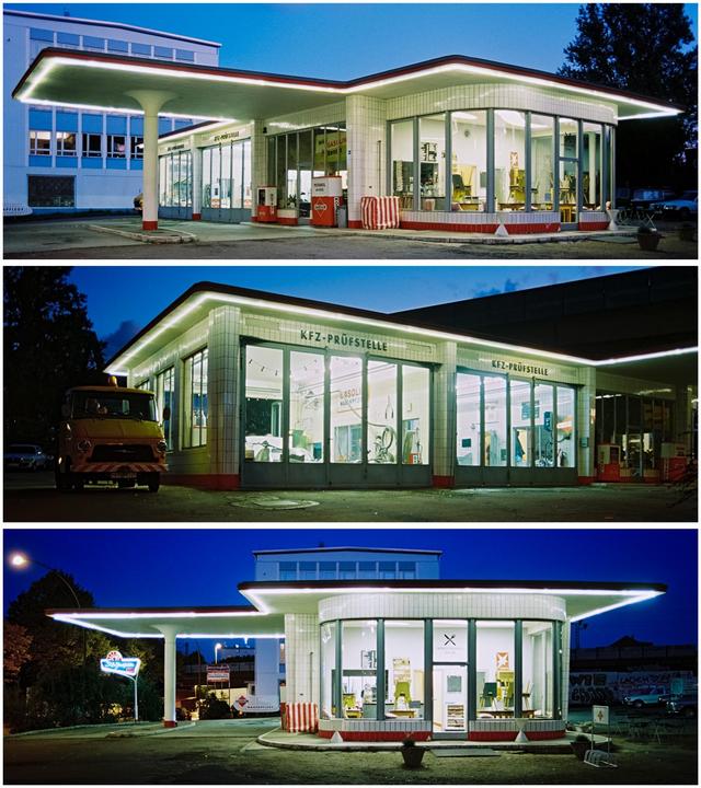 A vintage gas station with illuminated windows and a prominent sign is captured at night.