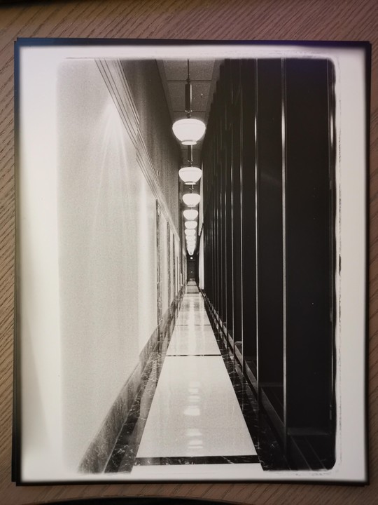 A long hallway with a row of lights on the ceiling stretches into the distance.