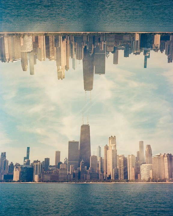 A double exposure shows the Chicago skyline right side up and upside down, with the John Hancock Center in the middle.
