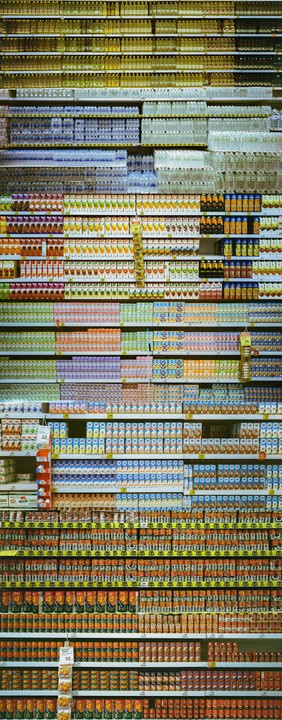 A panoramic shot shows shelves filled with various products in a grocery store.